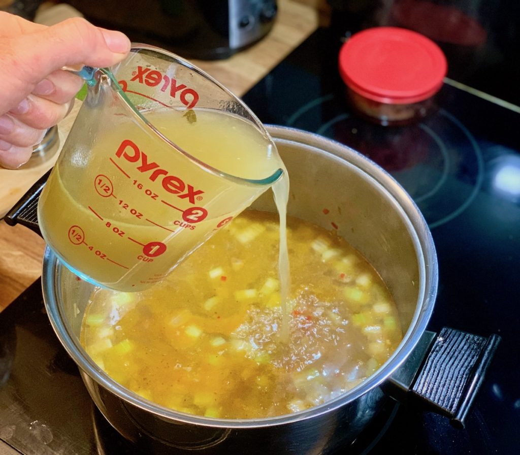 Adding broth when cooking rice to add flavor